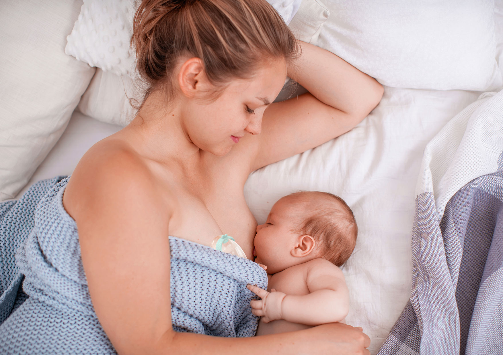 жінка, яка годує дитину груддю 